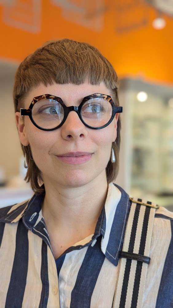Photograph of Aidan Hudson-Lapore. She is smiling and looking to the right.